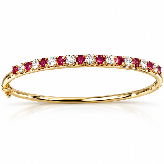 A yellow gold eternity bangle bracelet featuring a continuous row of round-cut pinkish-red and clear gemstones, displayed on a clean white background with a soft reflection.