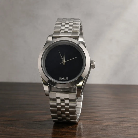 Rallé Men's Pure Time - Front view on dark wood surface showing minimalist matte black dial with silver-tone hands and Jubilee bracelet, reflecting refined craftsmanship and premium detail.