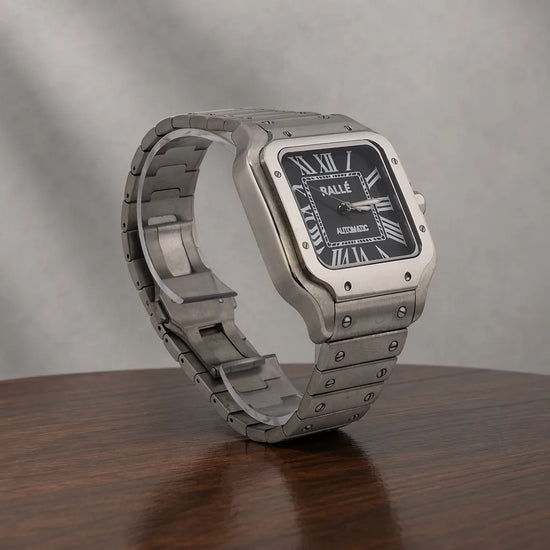 Close-up of Ralle Legacy Silver Automatic Watch with Black Dial on polished wood surface.